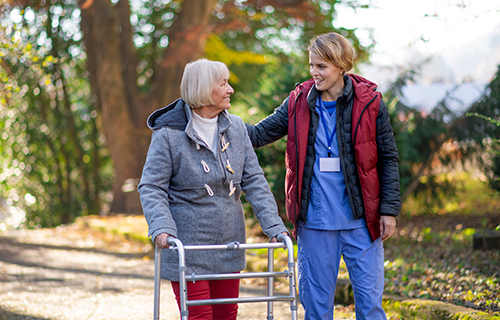 Caregiver walking with senior outside