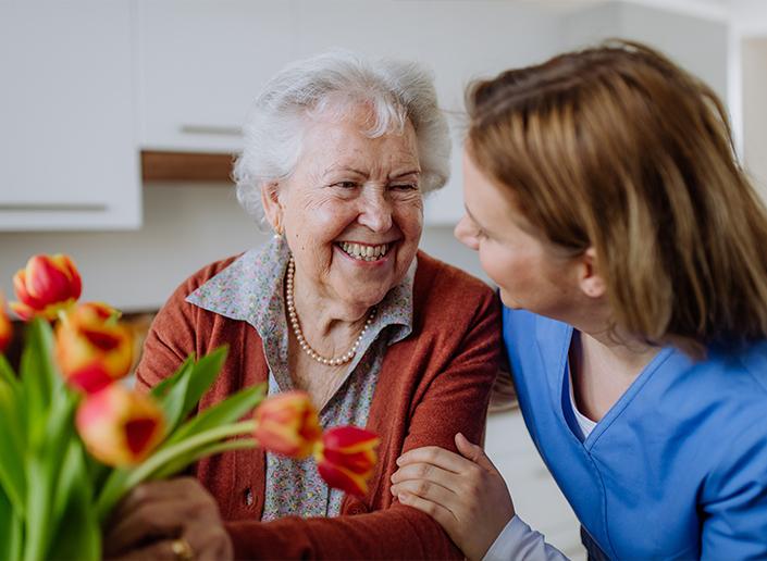 Senior with caretaker and flowers