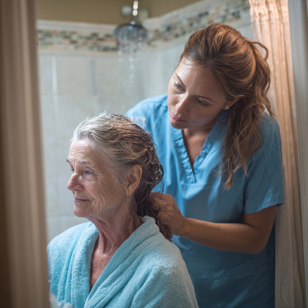 Caregiver gently helping an older woman with bathing routines as part of daily home care Santa Cruz, CA